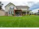 Expansive backyard showcasing a pergola, patio seating, a covered porch, lush lawn, and manicured landscaping at 4415 Voyageur Way, Carmel, IN 46074