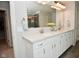 Bathroom featuring double sinks, a mirror, wood look tile flooring, and white cabinetry at 4415 Voyageur Way, Carmel, IN 46074