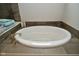 Bathroom featuring a soaking tub, wood-look tile flooring, and soft towels at 4415 Voyageur Way, Carmel, IN 46074