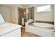Bathroom featuring a soaking tub, glass enclosed shower, and quartz countertops at 4415 Voyageur Way, Carmel, IN 46074