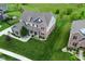 Beautiful two-story home boasts a well-manicured lawn, brick accents, and charming curb appeal at 4415 Voyageur Way, Carmel, IN 46074
