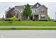 Charming two-story brick home with a well-manicured lawn and inviting front porch with stylish accents at 4415 Voyageur Way, Carmel, IN 46074