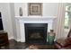 Elegant fireplace with white mantel, black surround, and decorative accents at 4415 Voyageur Way, Carmel, IN 46074