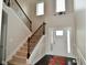 Elegant foyer with staircase, dark wood floors, wainscoting, and a decorative front door at 4415 Voyageur Way, Carmel, IN 46074