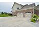 Spacious three-car garage with decorative doors, a basketball hoop, and well-maintained landscaping at 4415 Voyageur Way, Carmel, IN 46074