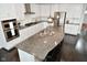 Modern island kitchen featuring stainless appliances, granite counters, bar seating, and custom cabinetry at 4415 Voyageur Way, Carmel, IN 46074