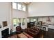 Open concept living room with a fireplace, ample natural light, and a view of the modern kitchen at 4415 Voyageur Way, Carmel, IN 46074