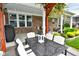 Covered patio with outdoor dining and seating area featuring a black metal table, comfortable chairs, and a charming lantern at 4415 Voyageur Way, Carmel, IN 46074