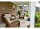 Relaxing covered patio with wicker seating, patterned rug, potted plants, and serene views of the well-maintained backyard at 4415 Voyageur Way, Carmel, IN 46074