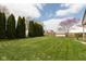 Expansive backyard with well-maintained lawn and privacy trees at 464 Hummingbird Ln, Whiteland, IN 46184