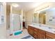 Bright bathroom featuring a double vanity, wooden cabinets, and a glass-enclosed shower at 464 Hummingbird Ln, Whiteland, IN 46184