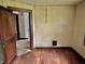 Cozy bedroom with hardwood floors, wood paneling, a window, and doorway access to another room at 505 W 40Th St, Indianapolis, IN 46208