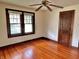 A well lit bedroom with hardwood floors, a ceiling fan and two windows providing a generous amount of natural light at 505 W 40Th St, Indianapolis, IN 46208