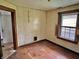 Bedroom featuring hardwood floors, wood paneling, a bright window, and access to other rooms at 505 W 40Th St, Indianapolis, IN 46208