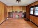 Cozy living room with hardwood floors, built-in cabinets, a brick fireplace, and wood-paneled walls at 505 W 40Th St, Indianapolis, IN 46208