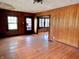 Living room featuring paneled walls, hardwood floors, ceiling lighting, and a doorway to another room at 505 W 40Th St, Indianapolis, IN 46208