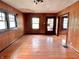 Spacious living room with wood paneled walls, hardwood floors, and large windows for natural light at 505 W 40Th St, Indianapolis, IN 46208