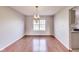 Bright dining room featuring hardwood floors, chandelier lighting, and a large window at 5397 Ripplingbrook Way, Carmel, IN 46033