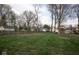 Large backyard with lush grass and surrounding trees, enclosed by fencing for added privacy at 5654 Broadway St, Indianapolis, IN 46220