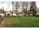 Spacious backyard featuring lush green grass, mature trees, and a fenced perimeter at 5654 Broadway St, Indianapolis, IN 46220