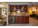 Basement bar with custom cabinets, tile backsplash, and beverage fridge at 5654 Broadway St, Indianapolis, IN 46220