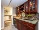 Basement wet bar featuring custom cabinetry, tile backsplash and a built-in beverage fridge at 5654 Broadway St, Indianapolis, IN 46220