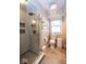 Bathroom with a glass shower, decorative tile and a modern chandelier at 5654 Broadway St, Indianapolis, IN 46220