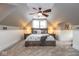 Cozy bedroom featuring carpet, a ceiling fan, a bed, bedside tables, and sloped ceilings at 5654 Broadway St, Indianapolis, IN 46220