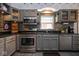 Modern kitchen with stainless steel appliances, granite countertops and dark tile backsplash at 5654 Broadway St, Indianapolis, IN 46220