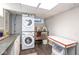 Functional laundry room featuring stacked washer/dryer and utility sink at 5654 Broadway St, Indianapolis, IN 46220