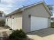 Exterior view of a two car garage with light siding, modern lighting, and manicured landscaping at 600 Fairlane Dr, Edinburgh, IN 46124