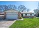 Charming single-story home featuring a brick facade, attached garage, and a well-maintained front yard at 617 Kokomo Ln, Indianapolis, IN 46241
