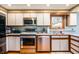Modern kitchen features stainless steel appliances, white cabinetry and a view from the window at 617 Kokomo Ln, Indianapolis, IN 46241