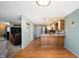 Open-concept space featuring laminate flooring connecting the living room with the kitchen and a back entry at 617 Kokomo Ln, Indianapolis, IN 46241