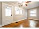 Bright bedroom featuring hardwood floors, a ceiling fan, and multiple windows offering natural light at 622 E 37Th St, Indianapolis, IN 46205