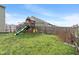 Large fenced backyard featuring a wooden play structure with slide and swings at 6316 Avacado Dr, Indianapolis, IN 46217
