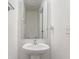 Small bathroom with a pedestal sink, large mirror, and white walls at 6316 Avacado Dr, Indianapolis, IN 46217