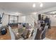 Open dining and living area with glass table, modern seating, and vinyl flooring at 6316 Avacado Dr, Indianapolis, IN 46217