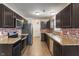 Functional kitchen featuring dark cabinets, laminate countertops, and stainless steel appliances at 6316 Avacado Dr, Indianapolis, IN 46217
