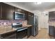 Well-lit kitchen features stainless steel appliances, dark wood cabinets, and a brick backsplash at 6316 Avacado Dr, Indianapolis, IN 46217