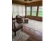 Bright sunroom boasts wood paneled walls, multiple windows, and a comfortable chair with an ottoman at 6389 N Forest St, Martinsville, IN 46151