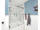 Recently remodeled bathroom with a tiled shower, a glass shower door, and nautical decor on the walls at 6436 Lakeland Blvd, Indianapolis, IN 46234