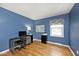 Bright bedroom with blue walls, hardwood floors, and a workstation at 6436 Lakeland Blvd, Indianapolis, IN 46234