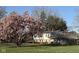 Lovely house with mature landscaping, manicured lawn and a flowering tree in the front yard at 6436 Lakeland Blvd, Indianapolis, IN 46234