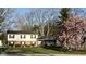 Charming two-story home with brick and vinyl siding, mature landscaping, and flowering tree at 6436 Lakeland Blvd, Indianapolis, IN 46234