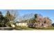 Home exterior featuring a mature flowering tree, well-maintained yard, and two-story construction at 6436 Lakeland Blvd, Indianapolis, IN 46234