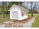 Quaint outbuilding with a garage door, red-shuttered windows, offering versatile space for storage or hobbies at 6436 Lakeland Blvd, Indianapolis, IN 46234