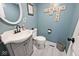 Stylish powder room with elegant vanity, modern fixtures, charming decor and wood-look flooring at 6436 Lakeland Blvd, Indianapolis, IN 46234
