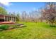 Expansive backyard featuring a lush lawn, flower beds, mature trees, and a charming screened-in porch at 6761 E Woodland Ct, Mooresville, IN 46158