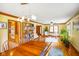 Open dining room with natural light, hardwood floors, a ceiling fan, and built-in bookshelves at 6761 E Woodland Ct, Mooresville, IN 46158